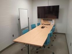 Table and chairs with monitor and whiteboard