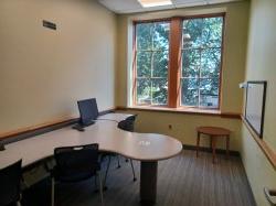 Study room with table, chair, computer, and whiteboard