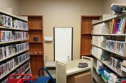 room with shelves of DVDs, a whiteboard and a cart